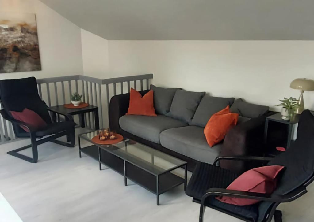 a living room with a couch and two chairs at Downtown with balcony in Tønsberg