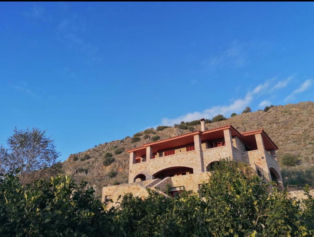 a house on top of a hill with trees at NafplioBiofarms Country Apartments in Nafplio