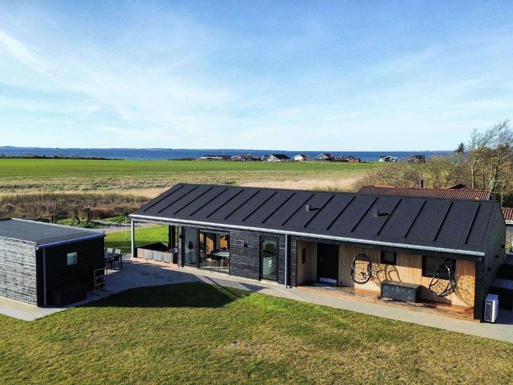a house with a black roof on top of a field at 10 person holiday home in Vinderup-By Traum in Vinderup