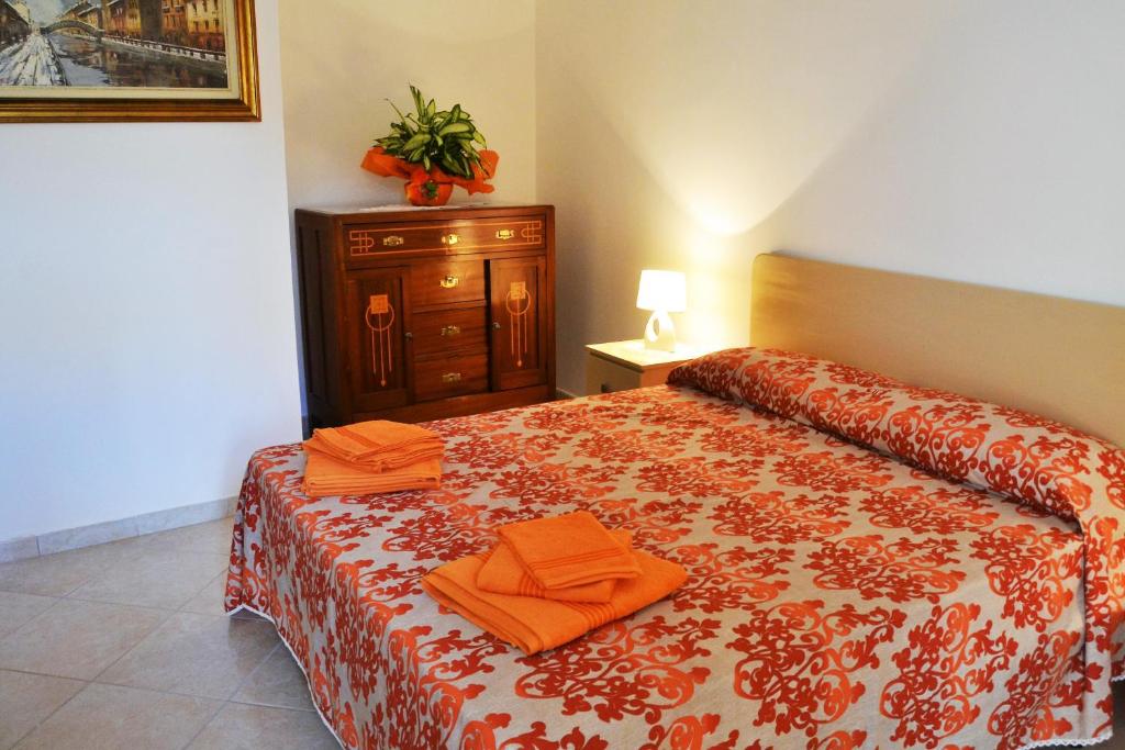 una camera da letto con un letto e asciugamani arancioni di I due Tesori a San Cesario di Lecce