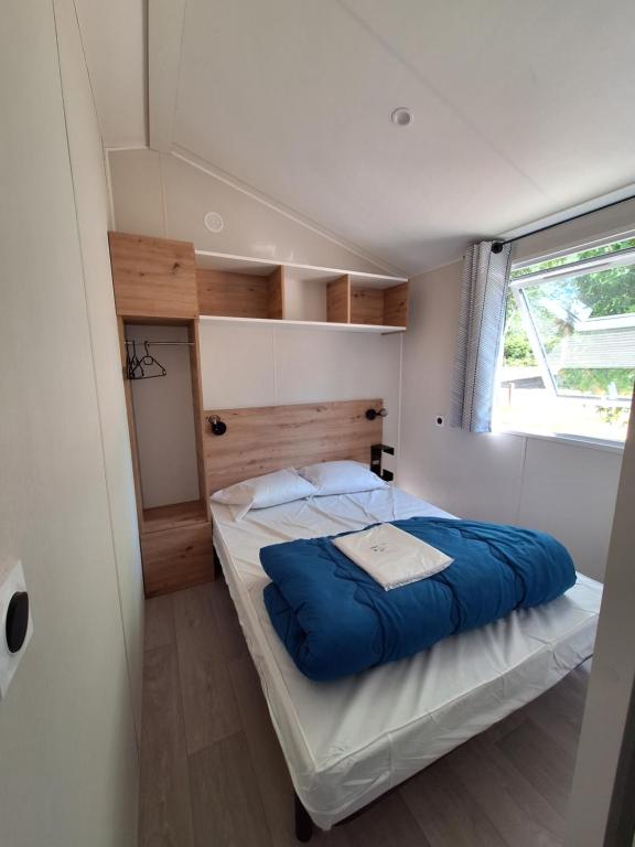 une petite chambre avec deux lits et une fenêtre dans l'établissement Camping des Papillons, à Lalizolle 49 autres photos