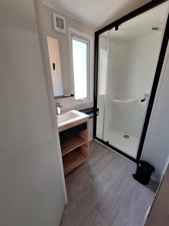 une salle de bain avec lavabo et douche dans l'établissement Camping des Papillons, à Lalizolle