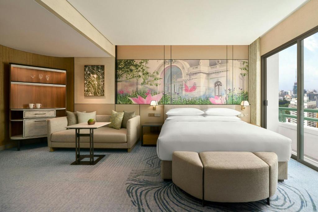 a hotel room with a large bed and a couch at Sheraton Saigon Grand Opera Hotel in Ho Chi Minh City