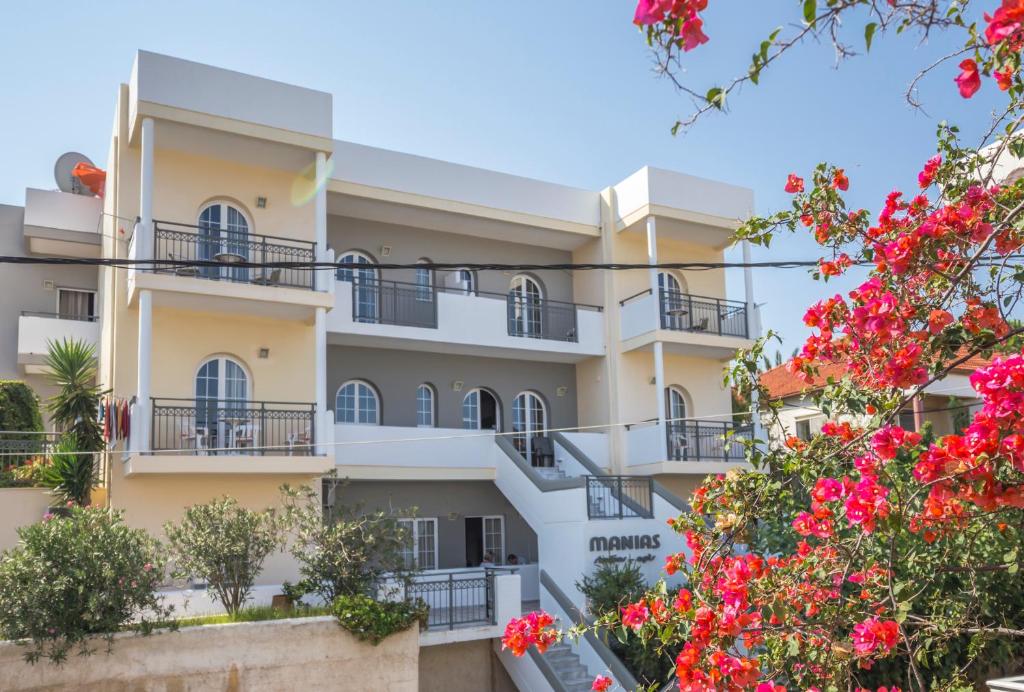 ein Gebäude mit Blumen davor in der Unterkunft Manias Hotel Apartments in Agia Marina