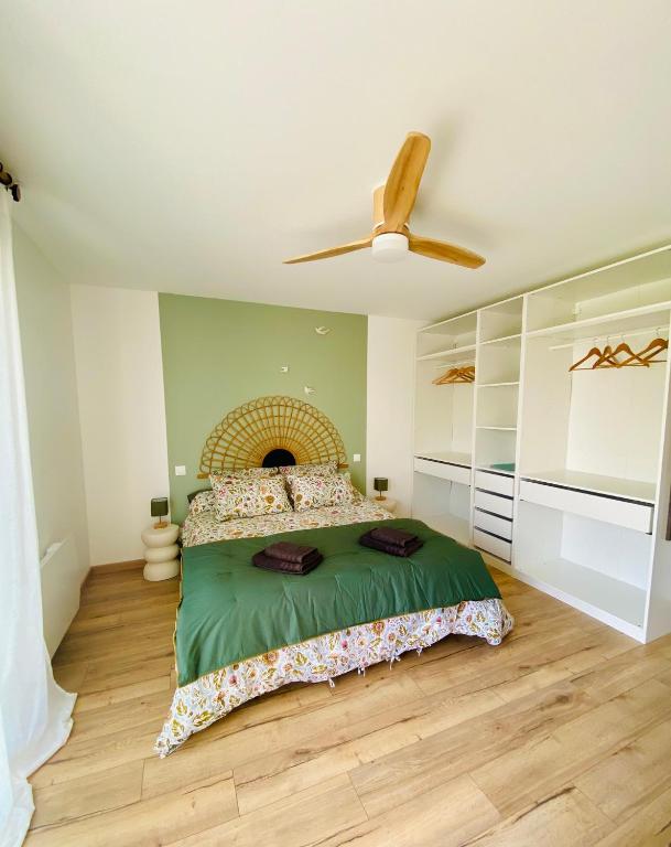 a bedroom with a bed and a ceiling fan at La Logette in Les Petites-Loges