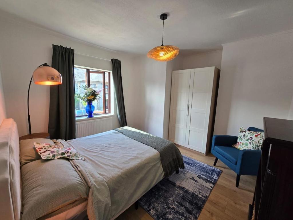 Un dormitorio con una cama y una silla azul. en Selene Apartment in Heart of Glastonbury, en Glastonbury