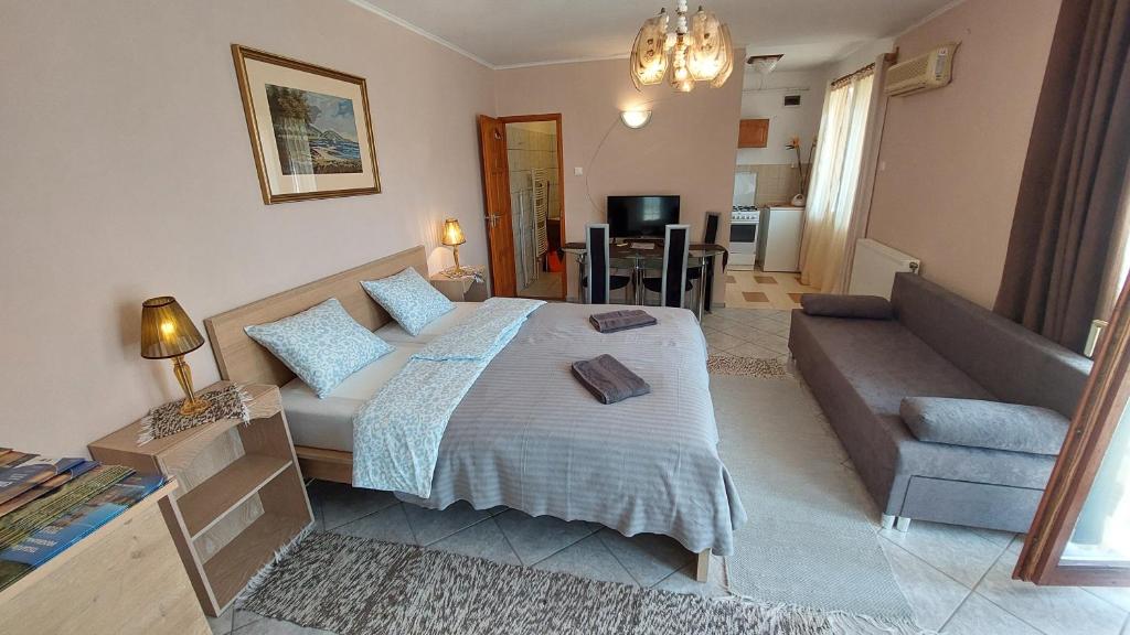 a bedroom with a large bed and a couch at Sétány Apartman-és Vendégház in Tiszafüred