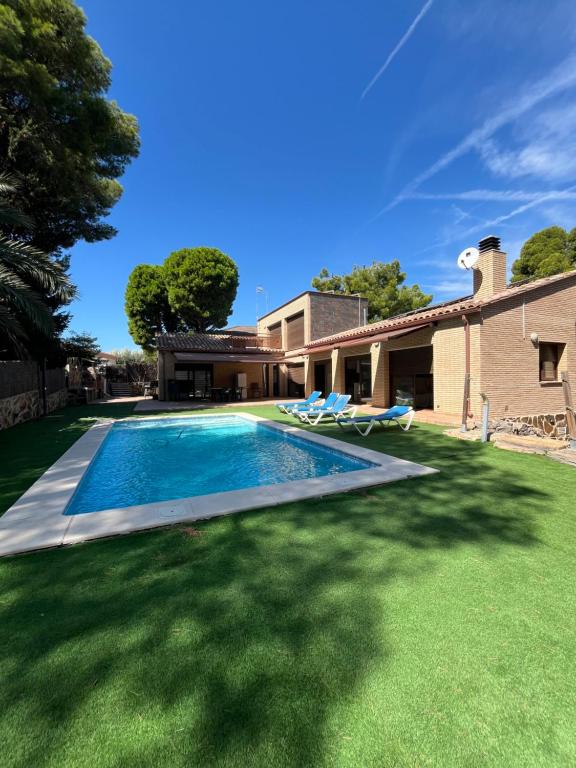 a swimming pool in the yard of a house at Villa Buiza in Cunit