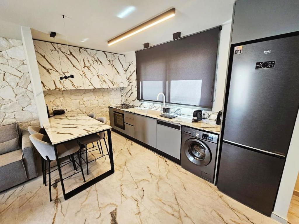a kitchen with a refrigerator and a table and a sink at Ethereal Residences Nafplio 4 in Nafplio