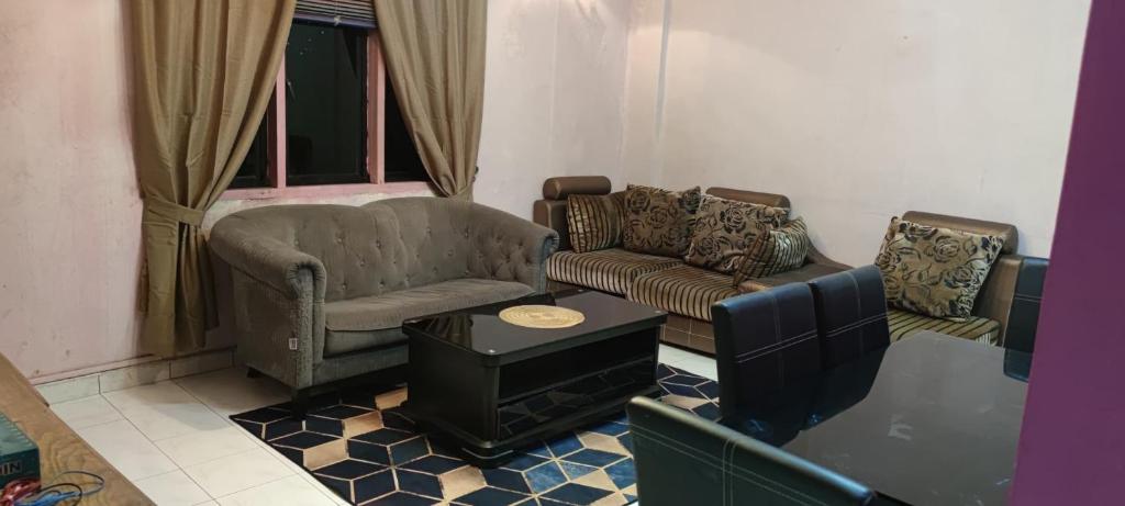 ein Wohnzimmer mit Sofa und Tisch in der Unterkunft Mia Homestay in Kuala Terengganu