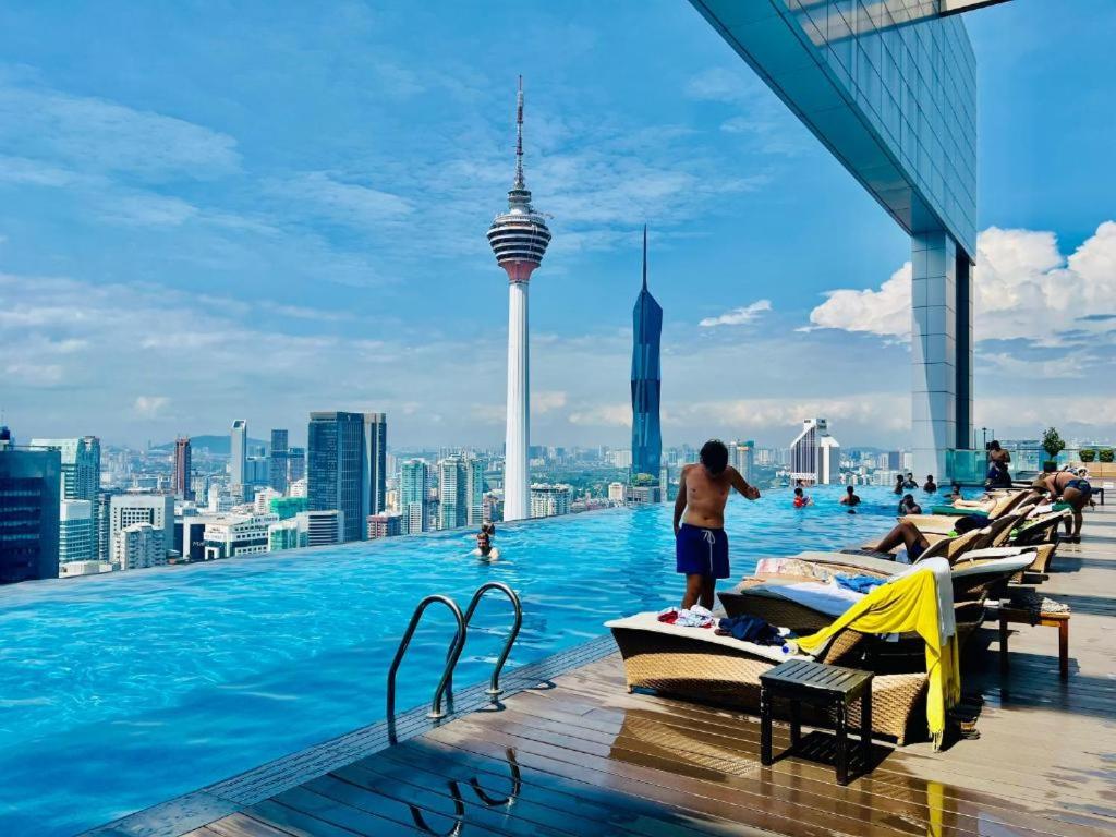 a infinity pool on the roof of a skyscraper with people swimming at The platinum KLCC by suites hospitality in Kuala Lumpur