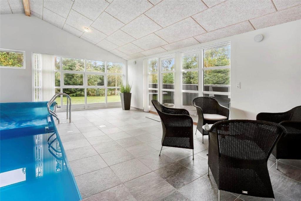 a room with a pool and chairs and a table at M12018-Vaeggerlose-Baeverstien-11 in Marielyst