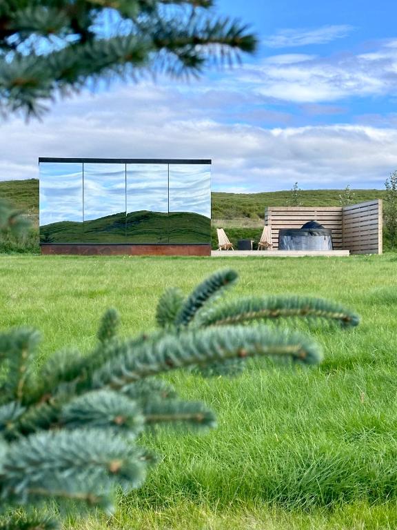 a view of a glass building in a field at Nest Retreat Iceland - Mirror Houses by the Rangá river in Hella
