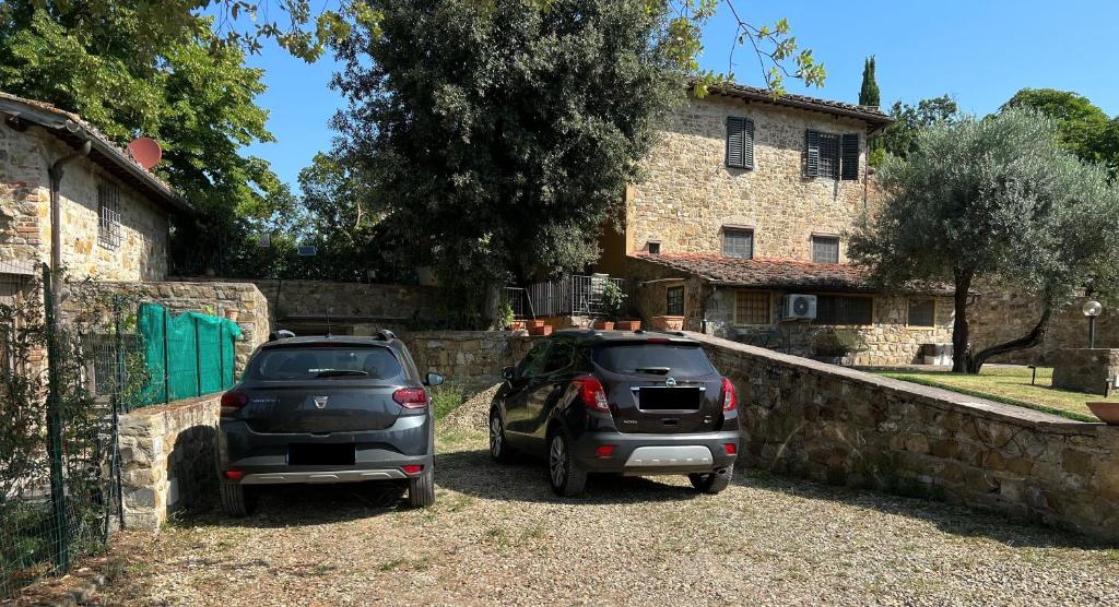 two cars parked in front of a stone wall at Villetta Gabriella in Impruneta