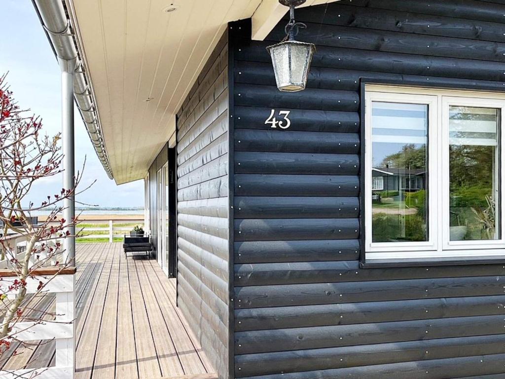 ein Haus mit einer schwarzen Wand und einem Fenster in der Unterkunft Secluded Retreat by Water - By Traum Ferienwohnungen in Bøjden