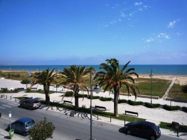 a parking lot with palm trees and the beach at Casa Paola - A due passi dal mare in Pozzallo
