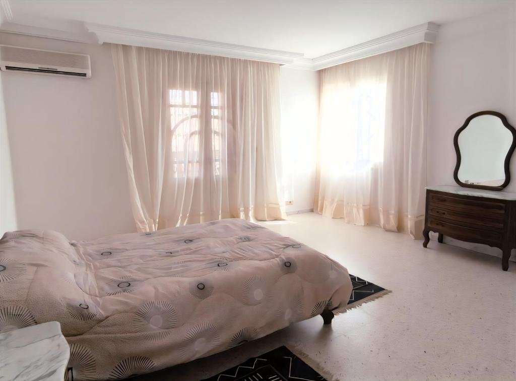 GabèsSunshine Villa的带床、梳妆台和窗户的卧室