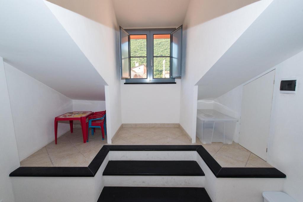 フィナーレ・リーグレにあるMansarda Cavassolaの階段、テーブル、窓が備わる客室です。