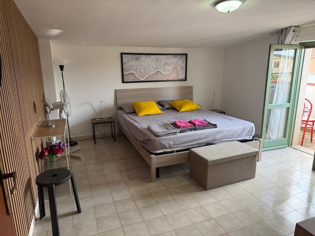 a bedroom with a bed with yellow and yellow pillows at ZIGI - Beautiful, sunny apartment, 70m2, close to the sea in Scalea