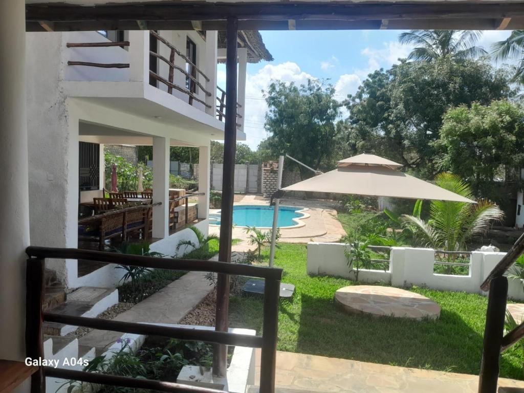 a view of a yard with a pool and an umbrella at SouthCoast Outdoors in Ukunda