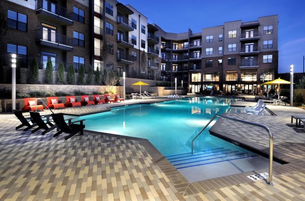 Una gran piscina con sillas y un edificio. en Cozy Luxury Home, en Atlanta