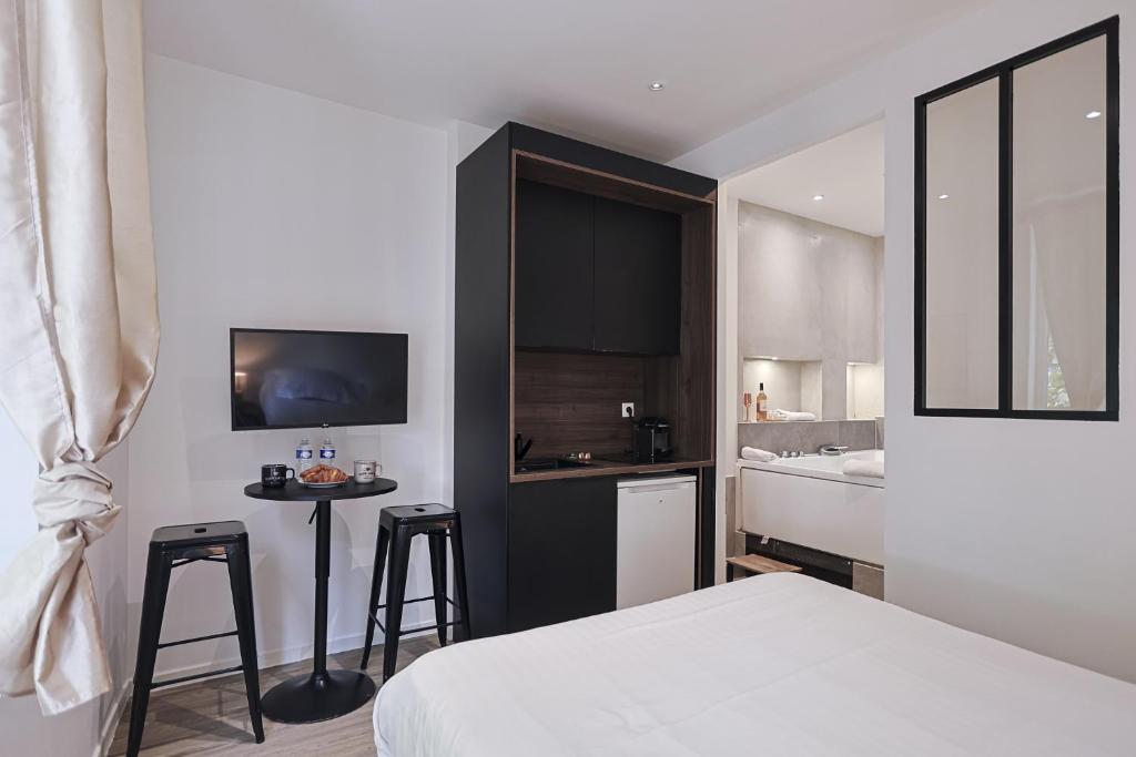 a bedroom with a bed and a kitchen with a counter at LES BULLES DE MONA - Passion - Spa - Clim in Lyon