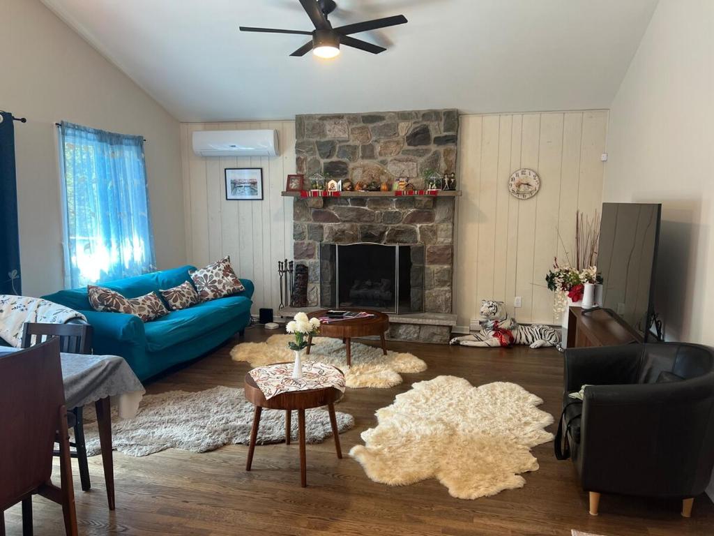 a living room with a blue couch and a fireplace at Evergreen Escapes 4 BR with Game Room, Firepit near Kalahari and Camelback in Long Pond