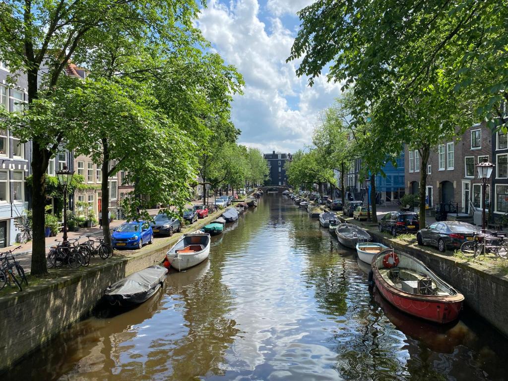 une rivière avec des bateaux garés sur ses côtés dans l'établissement JoyJoyJoy the White Wilde ecolicious studio in a historic Canalhouse from 1799 with terrace at the canals, à Amsterdam