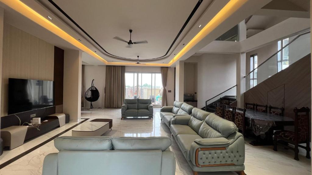 a large living room with couches and a television at Royal Elite - 6BHK Luxury Villa by Royal Villa Lonavla in Lonavala