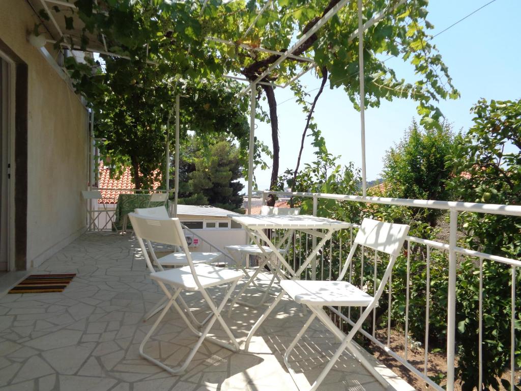 eine Terrasse mit weißen Stühlen und einem Tisch in der Unterkunft Apartment Prunus in Dubrovnik