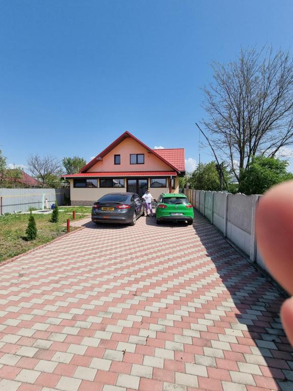two cars parked in front of a house at Door'In in Bacău