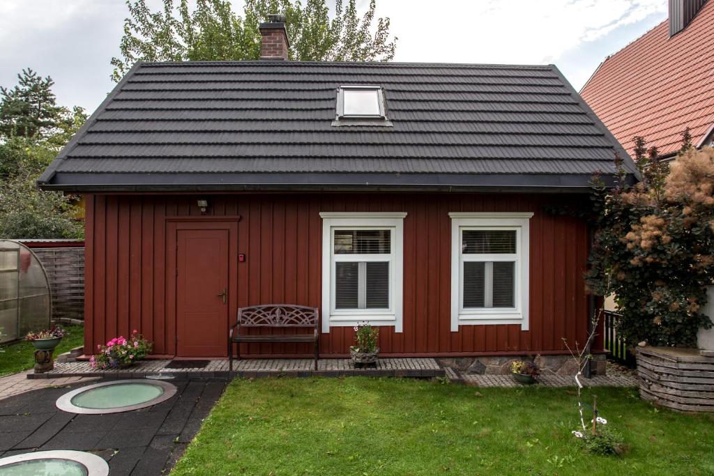 a red shed with a bench in a yard at Small House in Trakai Oldtown 1-6 sleeping places in Trakai