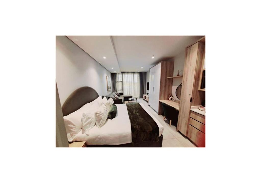 una camera da letto con un letto e una scrivania di Zimbali Lakes Boulevard Suites 138 a Ballito