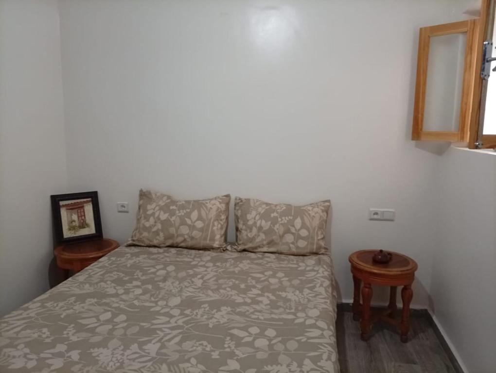 a bed in a room with two tables and a bed sidx sidx sidx at Maison Fatima in Essaouira