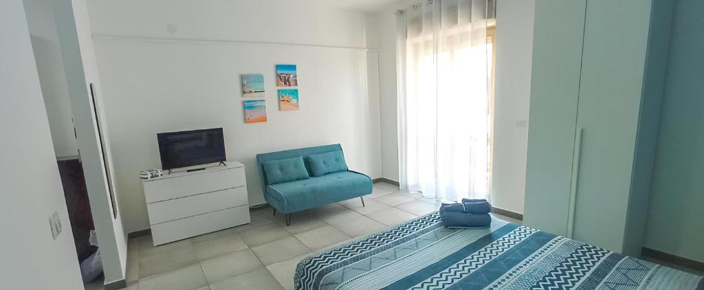 a bedroom with a bed and a tv and a chair at Perla blu Salento in Gallipoli
