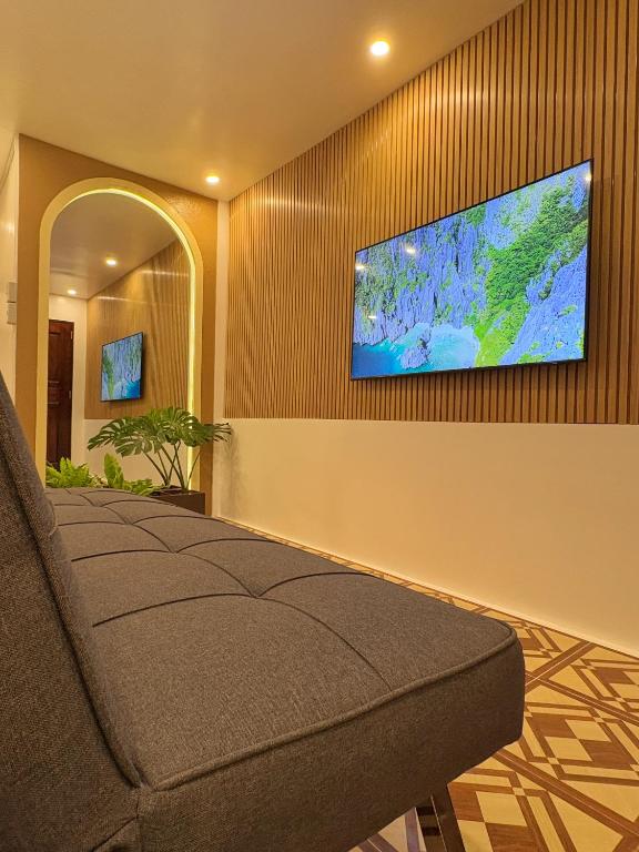a living room with a couch and a flat screen tv at La Luna Inn El Nido in El Nido