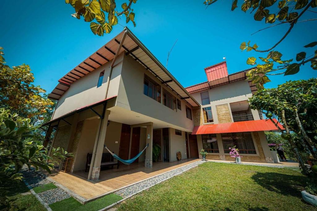 a house with a hammock in front of it at Puerto Bambú Nature and Relaxation in Moyobamba