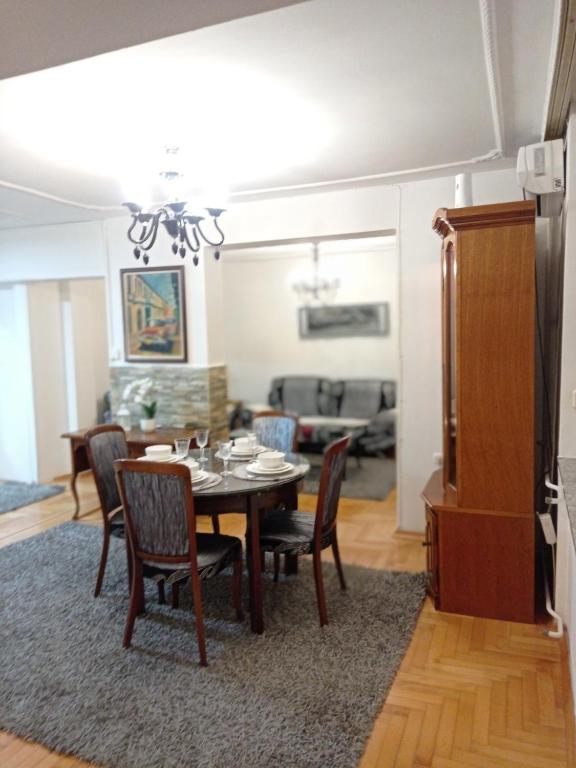 a dining room and living room with a table and chairs at Central Residence Banja Luka Spacious Apartment with Private Parking in Banja Luka