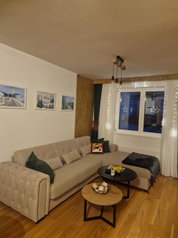 a living room with a couch and a table at Jahorina Woods - na stazi, ski-to-door in Jahorina