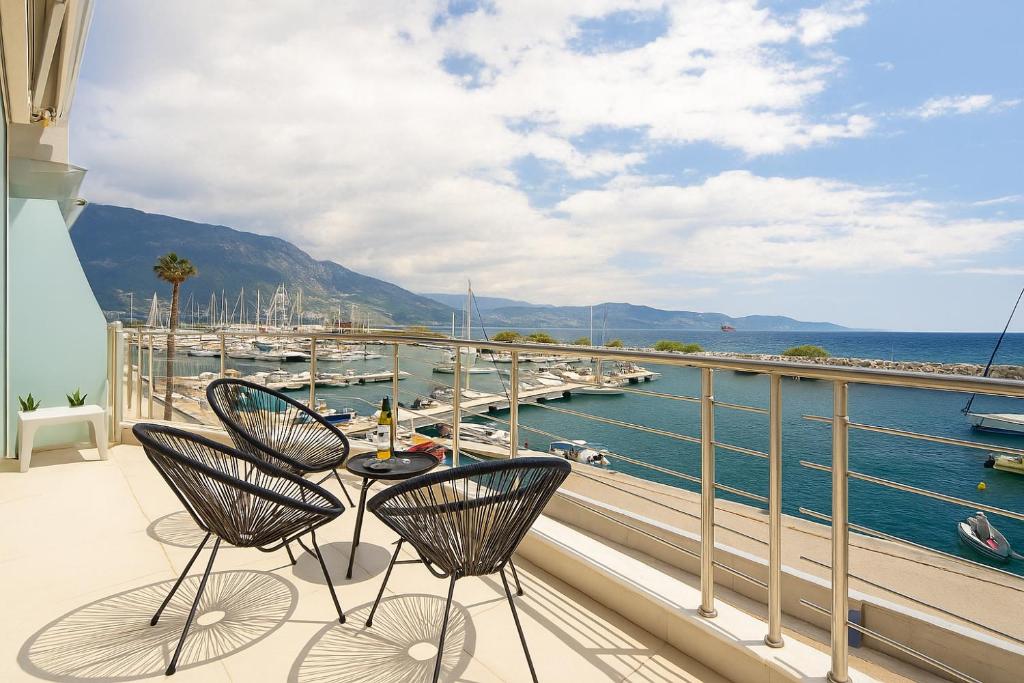 een balkon met stoelen en een tafel en uitzicht op het water bij Sail Away Home in Kalamata, Marina Serenity (B4) in Kalamata