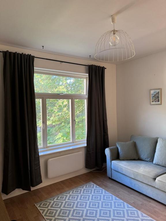 a living room with a couch and a window at Mo&Ko Kalamaja Apart - Self Check-in in Tallinn
