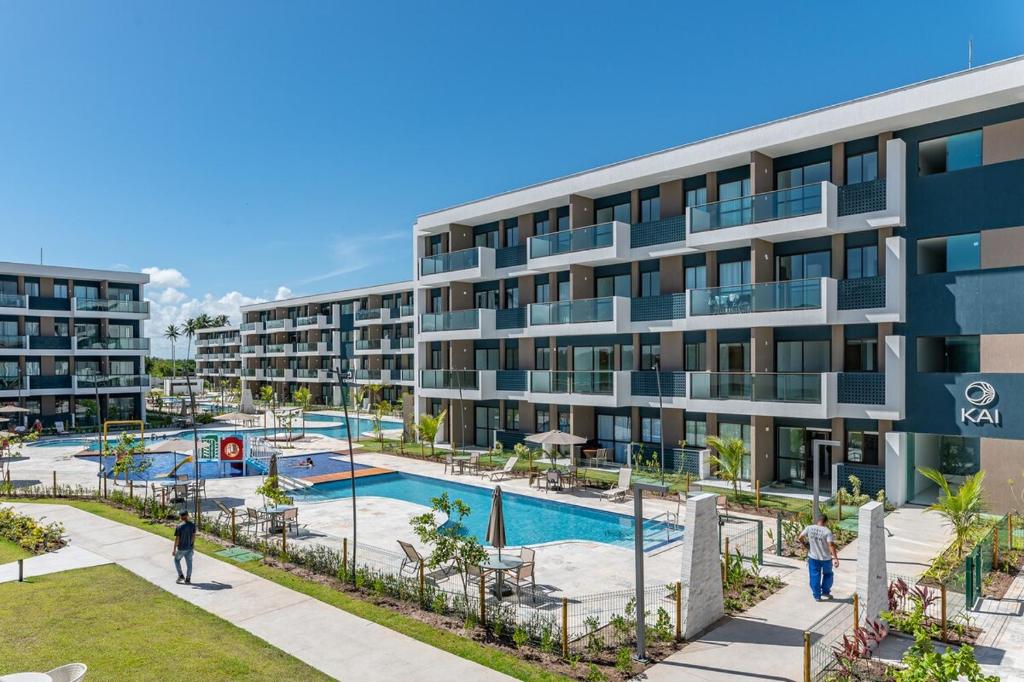 un immeuble d'appartements avec une piscine et un complexe dans l'établissement Makia Beach Experience- Flat 202D, à Ipojuca