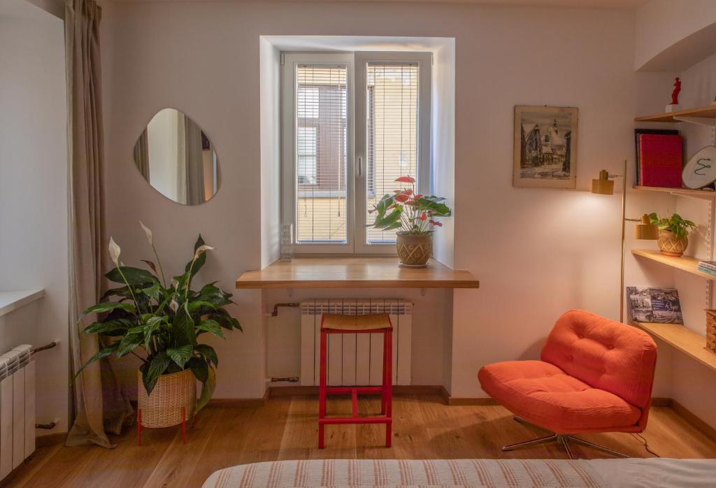 a living room with a table and a chair and a mirror at Cosy Studio on Wagner street, Riga Old Town in Rīga