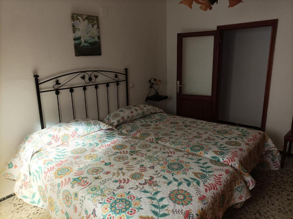 a bedroom with a bed with a floral comforter at Vivienda Vacacional Casa Uca in San Pedro