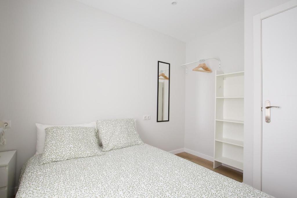 a white bedroom with a bed and a closet at Alberto Rooms habitaciones en piso compartido baño y zonas comunes compartido in Bilbao