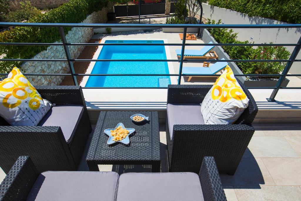 een patio met een tafel en stoelen naast een zwembad bij Holiday Home Vuko in Sevid
