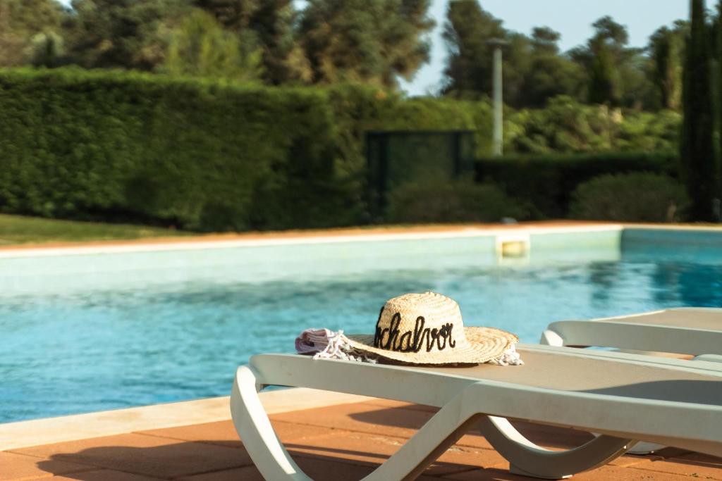 a hat sitting on a table next to a pool at RochAlvor in Alvor