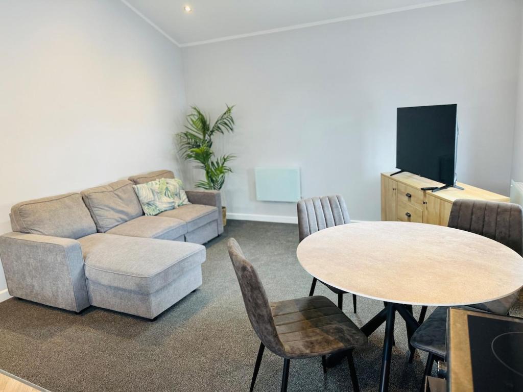 a living room with a couch and a table at 1 bed ground floor flat free parking in Peterborough