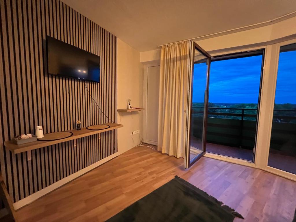 a living room with a television and a large window at Apart-Hotelzimmer mit Bergblick in Bad Essen in Bad Essen