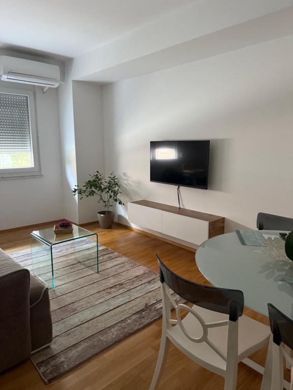 ein Wohnzimmer mit einem Tisch und einem TV an der Wand in der Unterkunft ViA prime central location in Ohrid